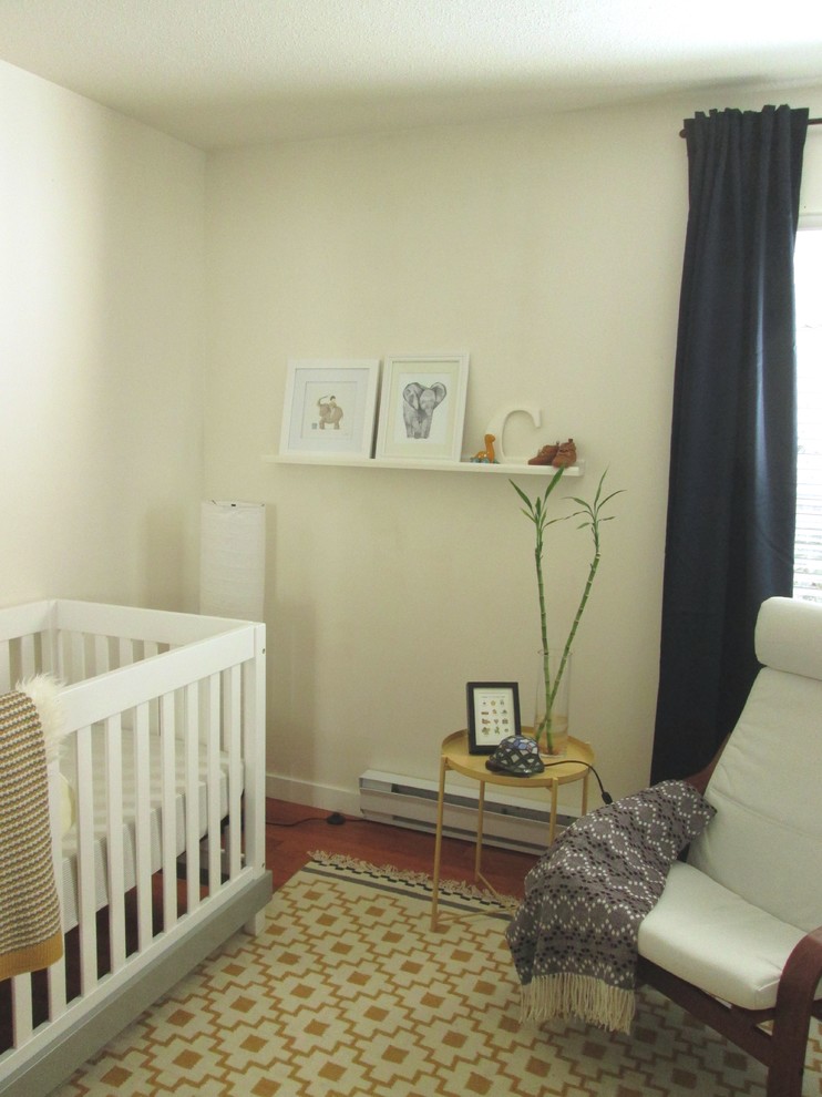 Small transitional nursery in Vancouver with white walls, medium hardwood floors and brown floor.