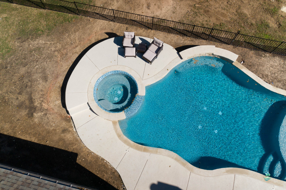 Photo of a large mediterranean back custom shaped natural hot tub in Dallas with concrete slabs.