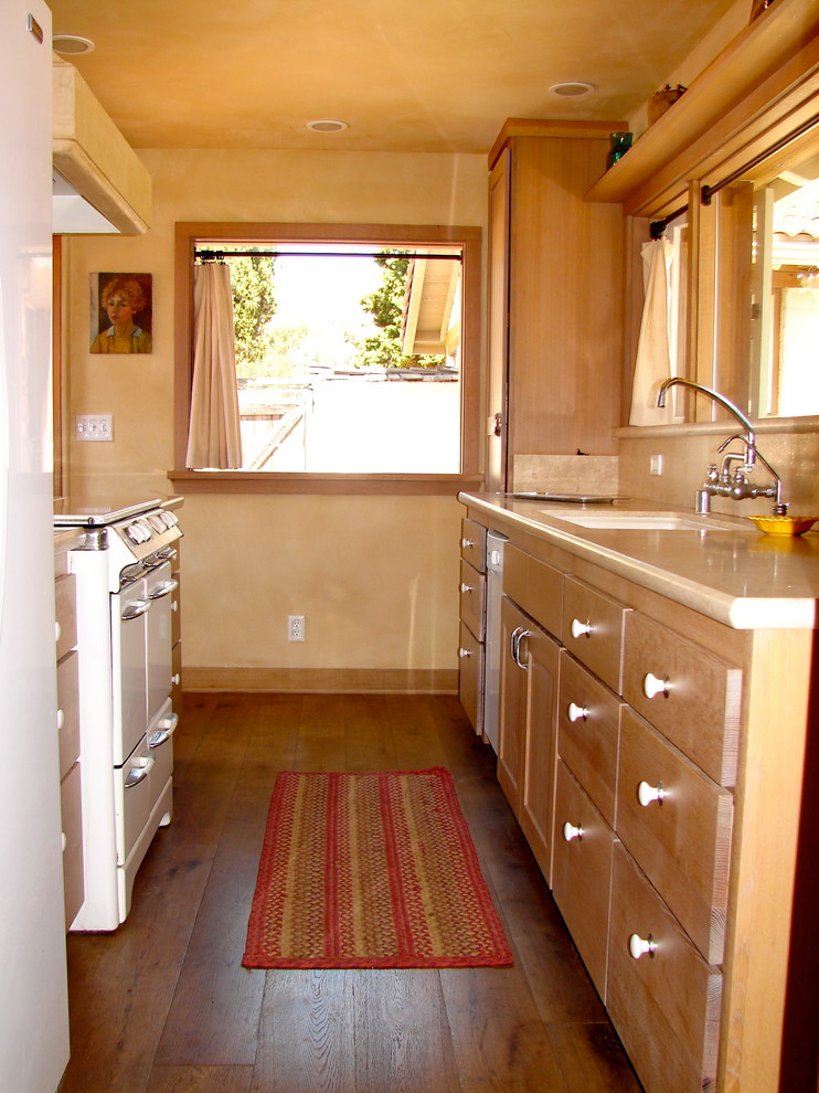 Kitchen - small mediterranean galley medium tone wood floor and brown floor kitchen idea in San Francisco with an undermount sink, flat-panel cabinets, medium tone wood cabinets, quartz countertops, white appliances and beige countertops