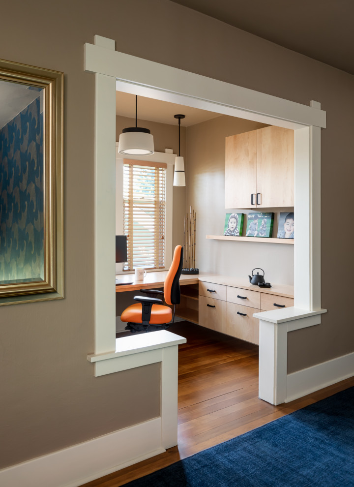 Kleines Nordisches Arbeitszimmer ohne Kamin mit Studio, beiger Wandfarbe, braunem Holzboden, Einbau-Schreibtisch, braunem Boden und Deckengestaltungen in Seattle