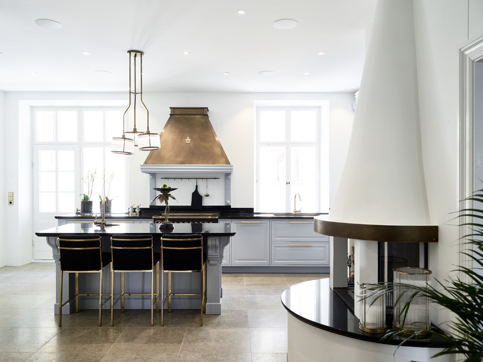 Design ideas for a large traditional galley kitchen in Gothenburg with limestone floors, with island, grey floor, black benchtop, blue cabinets and raised-panel cabinets.