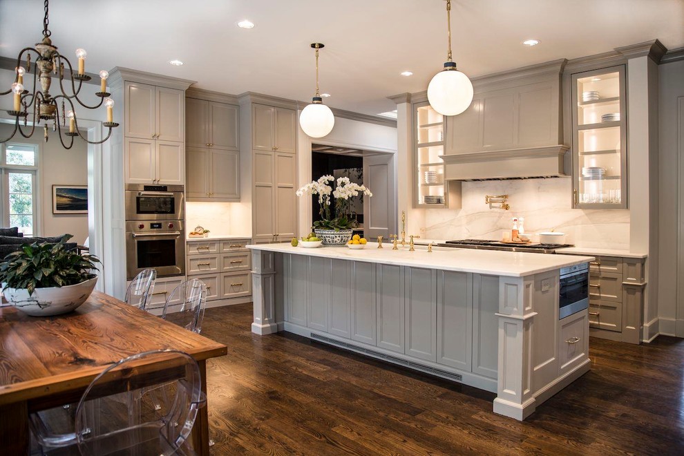 Example of a huge transitional l-shaped dark wood floor kitchen design in Austin with a farmhouse sink, recessed-panel cabinets, gray cabinets, marble countertops, white backsplash, marble backsplash, stainless steel appliances, an island and white countertops