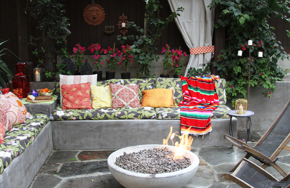 Inspiration for an eclectic patio in Los Angeles with a fire feature and no cover.