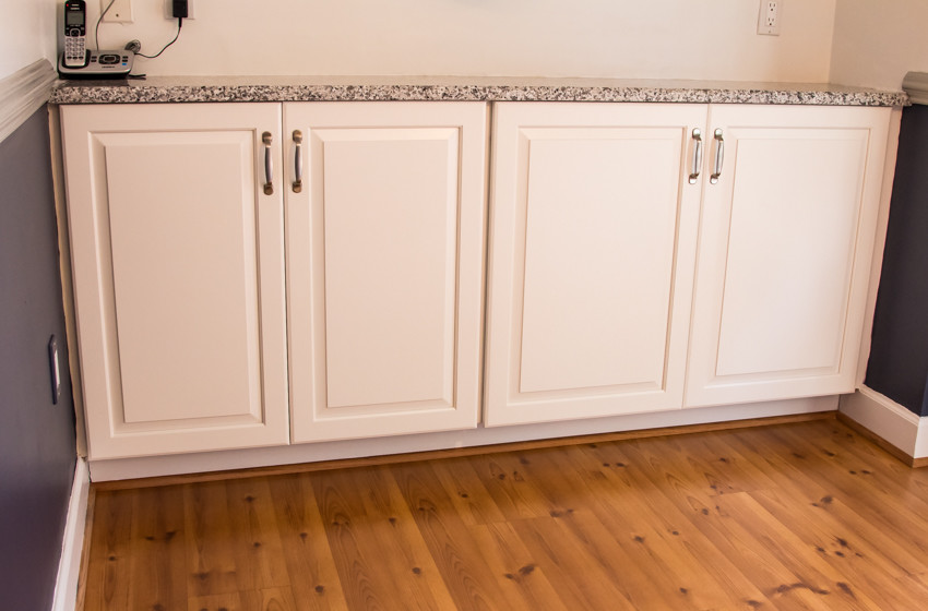 Kitchen - small transitional u-shaped light wood floor kitchen idea in Baltimore with an undermount sink, raised-panel cabinets, white cabinets and no island
