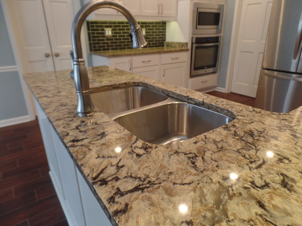 Example of a large transitional u-shaped porcelain tile eat-in kitchen design with an undermount sink, shaker cabinets, white cabinets, quartz countertops, green backsplash, glass tile backsplash, stainless steel appliances and a peninsula