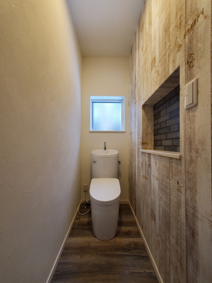 Immagine di un bagno di servizio american style con WC monopezzo, pareti marroni, pavimento in legno verniciato, pavimento marrone, soffitto in carta da parati e carta da parati