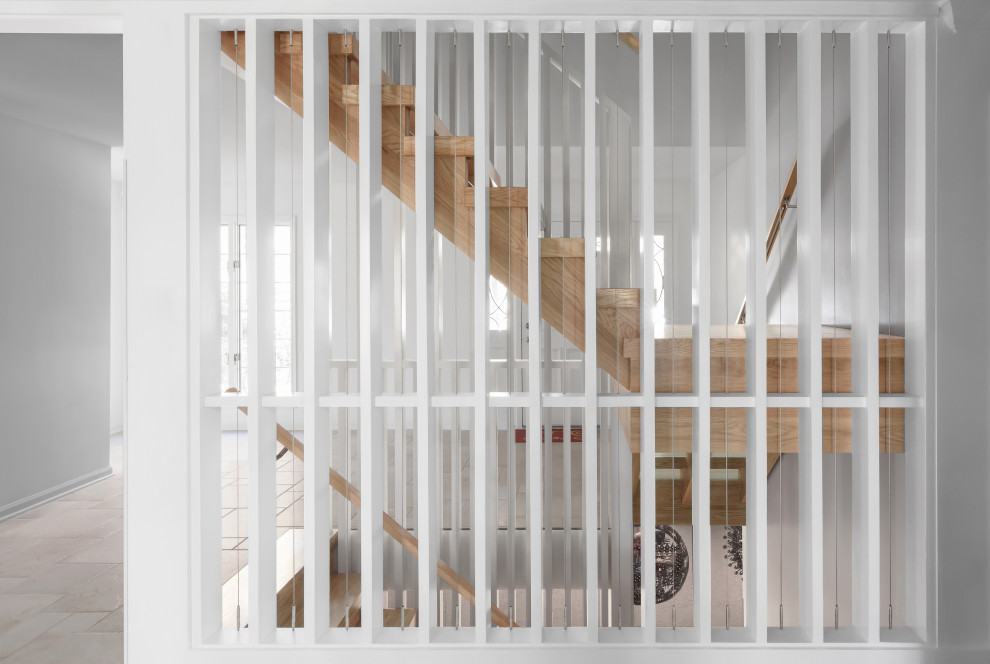 На фото: угловая лестница среднего размера в скандинавском стиле с деревянными ступенями, деревянными перилами и деревянными стенами без подступенок