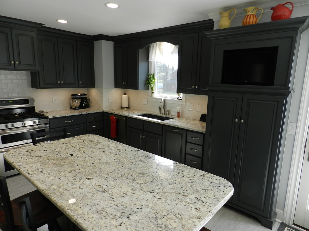 Inspiration for a mid-sized transitional l-shaped separate kitchen in Cleveland with an undermount sink, raised-panel cabinets, grey cabinets, granite benchtops, white splashback, subway tile splashback, stainless steel appliances, porcelain floors, with island and beige floor.