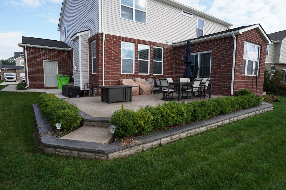 Ejemplo de patio moderno de tamaño medio sin cubierta en patio trasero con suelo de hormigón estampado