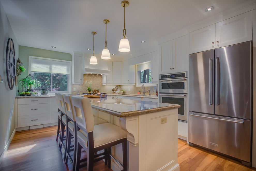 Inspiration for a mid-sized transitional l-shaped medium tone wood floor eat-in kitchen remodel in Toronto with an undermount sink, shaker cabinets, white cabinets, quartzite countertops, brown backsplash, stone slab backsplash, stainless steel appliances and an island