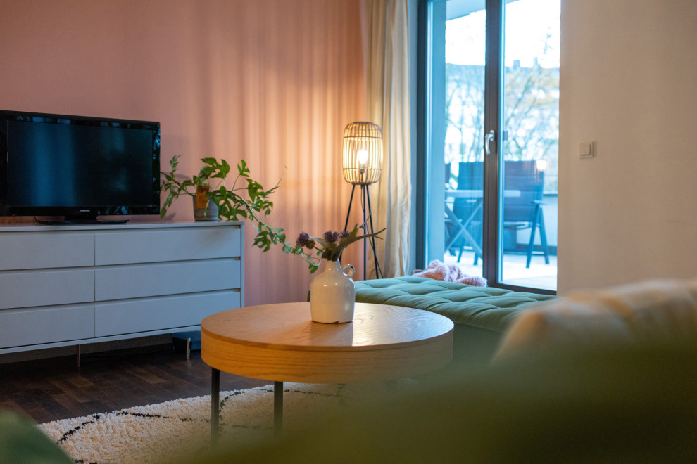 Mittelgroßes, Offenes Modernes Wohnzimmer ohne Kamin mit rosa Wandfarbe, dunklem Holzboden, freistehendem TV, braunem Boden und eingelassener Decke in Köln