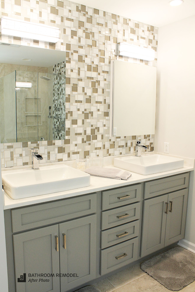 Mid-sized beach style master bathroom in Other with shaker cabinets, grey cabinets, a freestanding tub, a corner shower, a one-piece toilet, multi-coloured tile, glass sheet wall, beige walls, ceramic floors, a drop-in sink and engineered quartz benchtops.