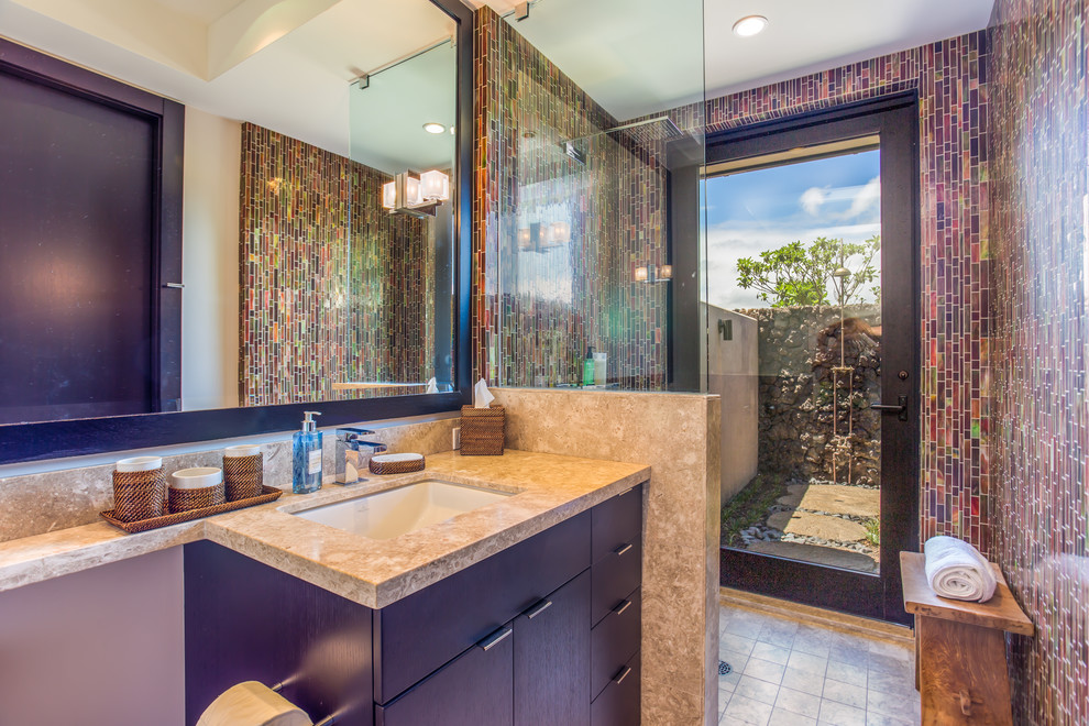 Design ideas for a mid-sized contemporary 3/4 bathroom in Hawaii with an undermount sink, flat-panel cabinets, dark wood cabinets, granite benchtops, an open shower, a one-piece toilet, multi-coloured tile, glass tile, multi-coloured walls and limestone floors.