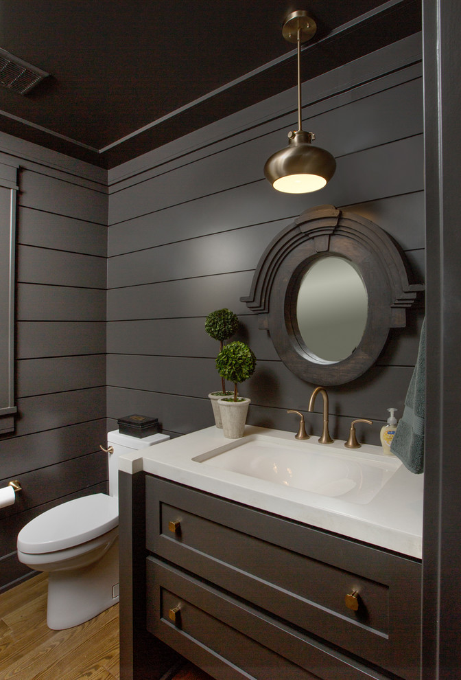 Photo of a transitional bathroom in Columbus with dark wood cabinets and white benchtops.
