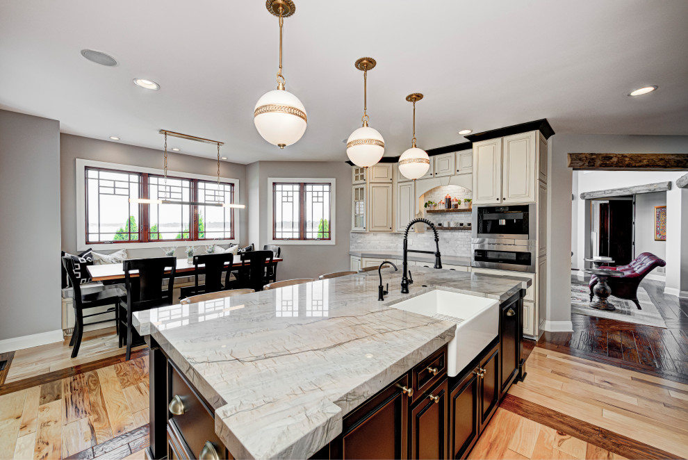 Enclosed kitchen - mid-sized eclectic galley medium tone wood floor enclosed kitchen idea in Indianapolis with an undermount sink, shaker cabinets, granite countertops, subway tile backsplash, stainless steel appliances, an island, gray countertops and gray backsplash
