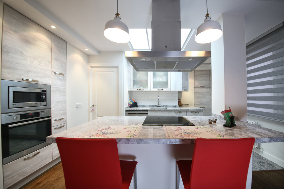 Modelo de cocina clásica renovada grande abierta con armarios con paneles lisos, electrodomésticos de acero inoxidable y península