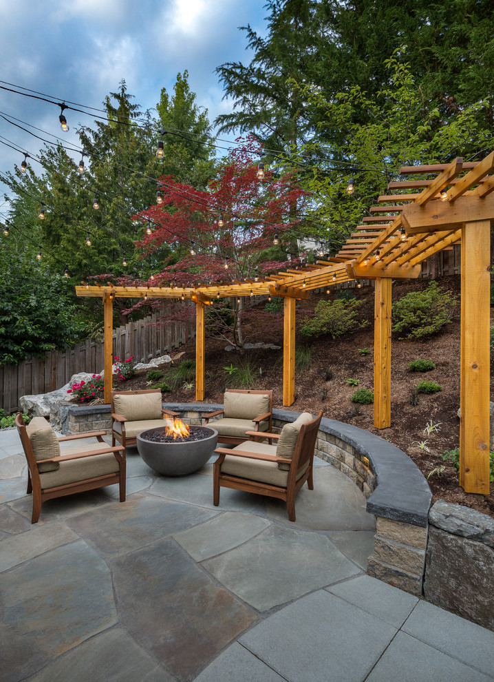 Photo of a large transitional backyard patio in Seattle with a fire feature, natural stone pavers and a pergola.