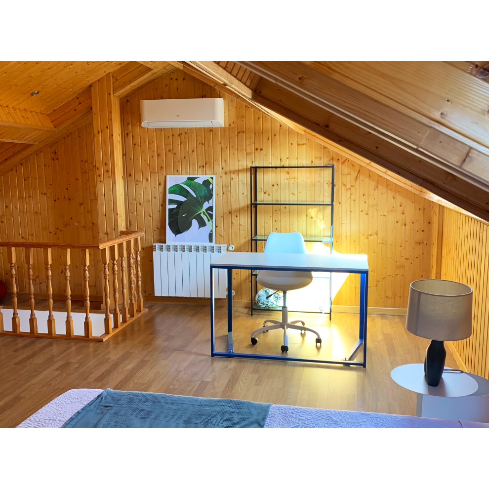 Modelo de dormitorio tipo loft y blanco y madera rural de tamaño medio con paredes marrones, suelo laminado, suelo marrón, techo inclinado, madera y con escritorio