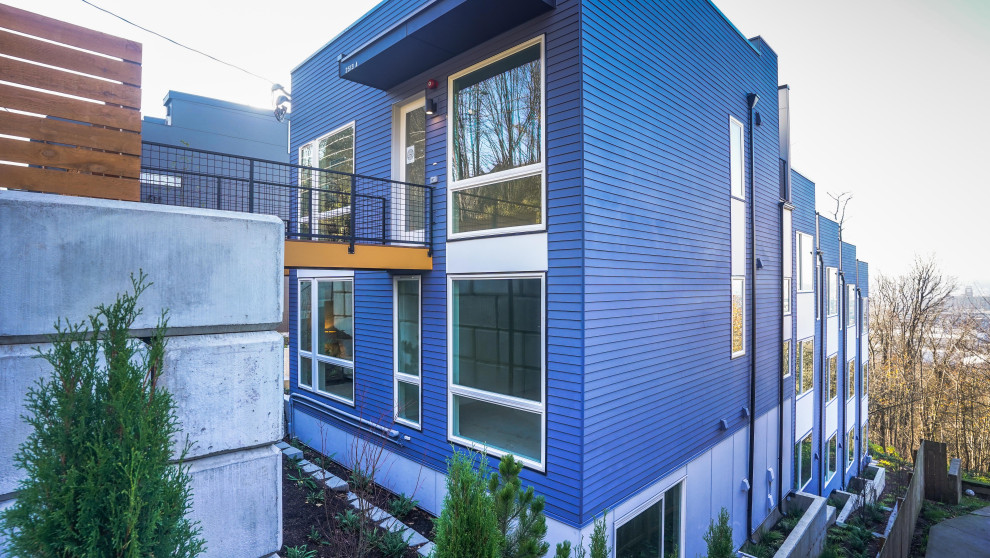 Idées déco pour une façade de maison de ville bleue contemporaine en bois et bardage à clin.
