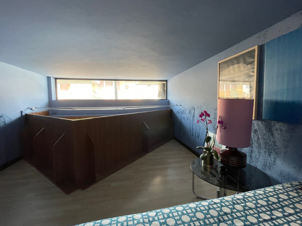 На фото: маленькая спальня на антресоли с синими стенами, полом из ламината, бежевым полом и многоуровневым потолком для на участке и в саду