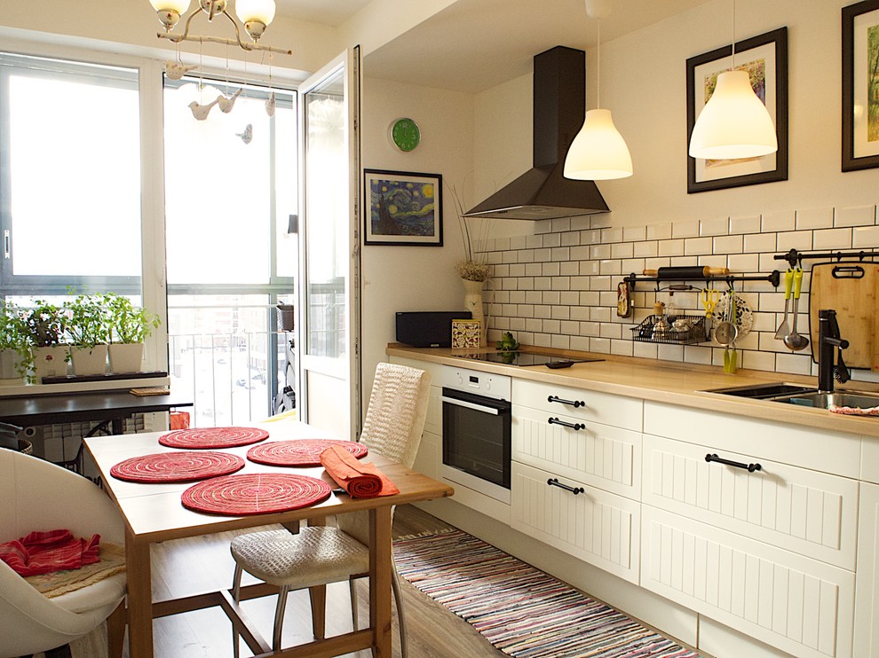 Inspiration for a small scandinavian l-shaped eat-in kitchen in Yekaterinburg with raised-panel cabinets, white cabinets, laminate benchtops, white splashback, white appliances, medium hardwood floors, no island, a double-bowl sink and subway tile splashback.