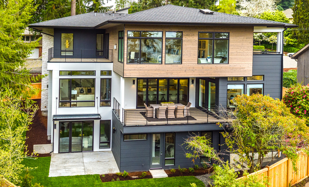 Large transitional two-storey multi-coloured house exterior in Seattle with mixed siding and a shingle roof.