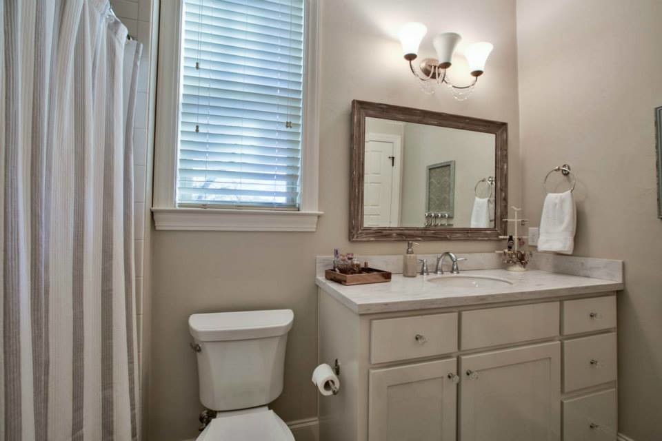 Photo of a mid-sized beach style master bathroom in Atlanta with shaker cabinets, white cabinets, a drop-in tub, a corner shower, a two-piece toilet, stone tile, white walls, vinyl floors, an undermount sink and marble benchtops.