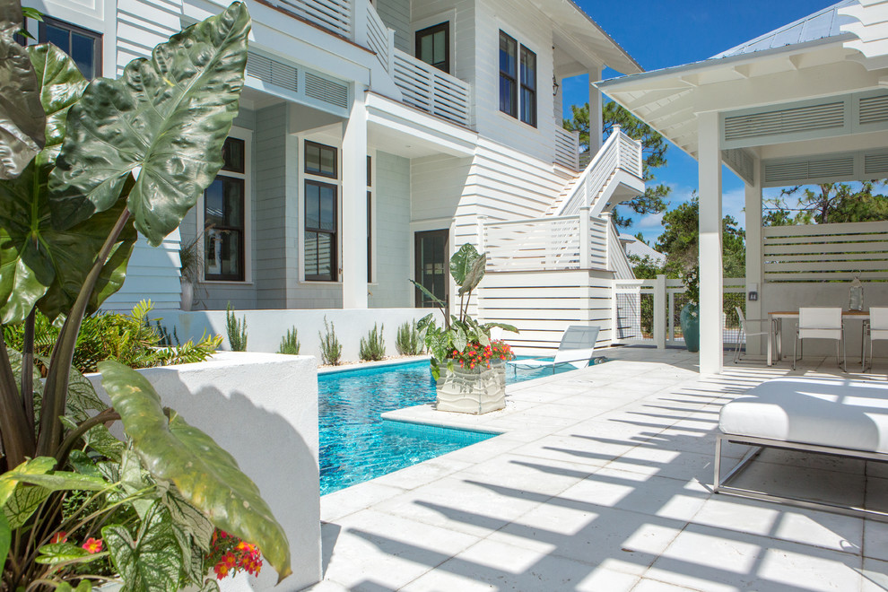 Small beach style backyard rectangular pool in Miami with a water feature and concrete pavers.