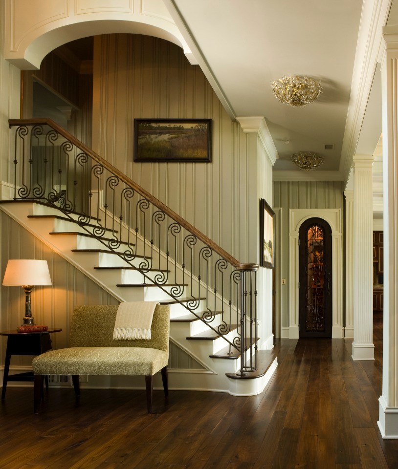 This is an example of a large tropical hallway in Charleston with beige walls, dark hardwood floors and brown floor.