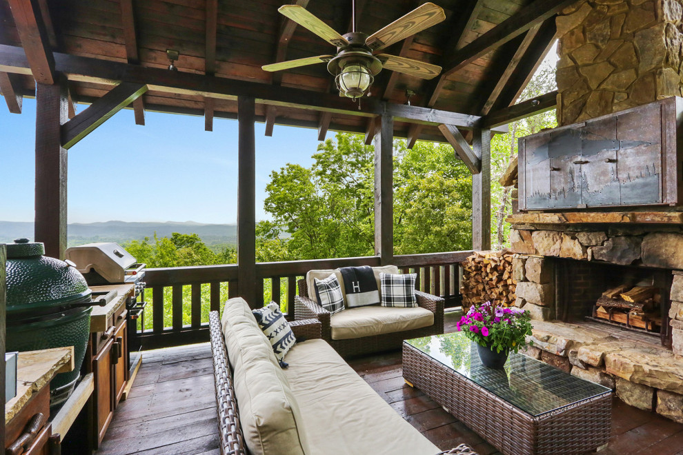 Inspiration for a large country side yard deck in Atlanta with with fireplace and a roof extension.