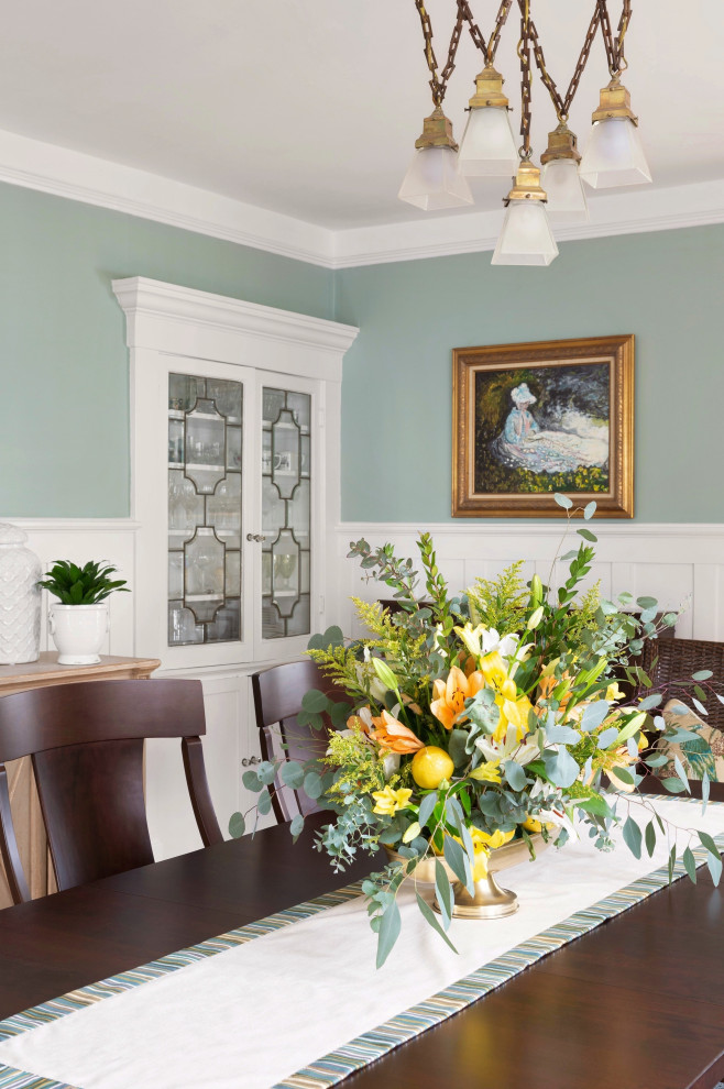 Example of a huge classic light wood floor and wainscoting dining room design with green walls, a standard fireplace and a tile fireplace