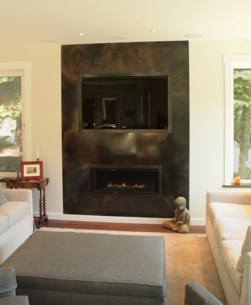 Example of a trendy living room design in Vancouver with a media wall, a standard fireplace and a metal fireplace