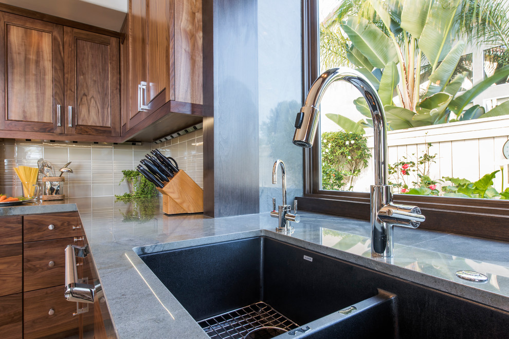 Open concept kitchen - large transitional l-shaped ceramic tile and gray floor open concept kitchen idea with an undermount sink, recessed-panel cabinets, dark wood cabinets, granite countertops, multicolored backsplash, mosaic tile backsplash, stainless steel appliances and an island