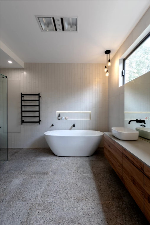 Exempel på ett stort modernt grå grått badrum, med släta luckor, skåp i mellenmörkt trä, ett fristående badkar, en toalettstol med hel cisternkåpa, vit kakel, keramikplattor, vita väggar, terrazzogolv, ett fristående handfat, bänkskiva i kvarts, grått golv och dusch med gångjärnsdörr