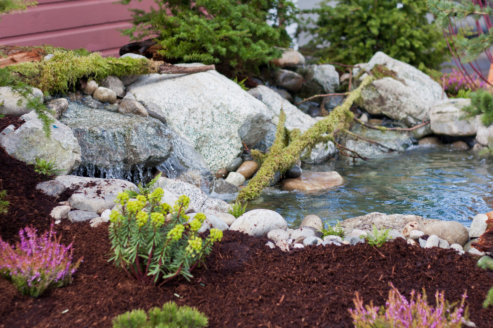 Inspiration for a mid-sized rustic partial sun backyard stone formal garden in Seattle for spring.