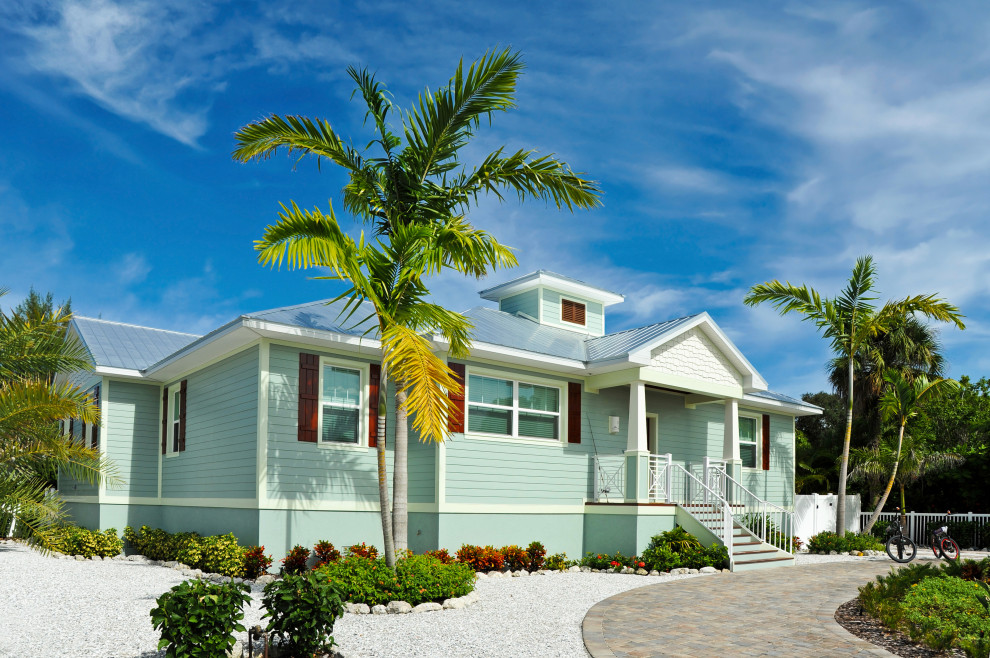 Стильный дизайн: большой, одноэтажный, зеленый частный загородный дом в морском стиле с облицовкой из металла, двускатной крышей, металлической крышей, синей крышей и отделкой планкеном - последний тренд