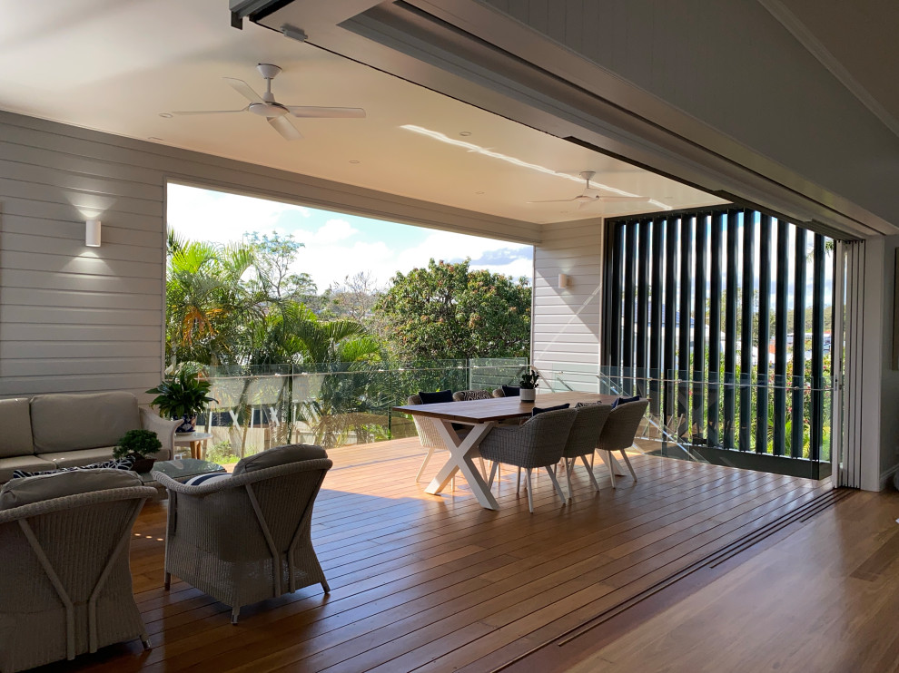 Design ideas for a large contemporary backyard and first floor deck in Brisbane with with privacy feature, a roof extension and mixed railing.