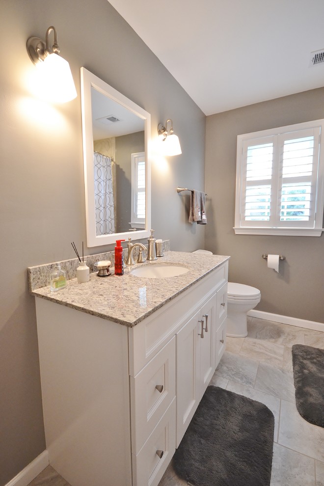 Large transitional 3/4 beige tile and ceramic tile ceramic tile home design photo in Philadelphia with raised-panel cabinets, white cabinets, a one-piece toilet, beige walls, an undermount sink and granite countertops