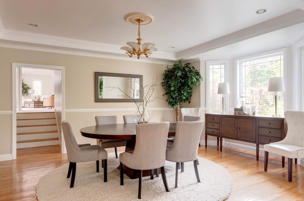 This is an example of a large traditional open plan dining in Boston with beige walls and light hardwood floors.