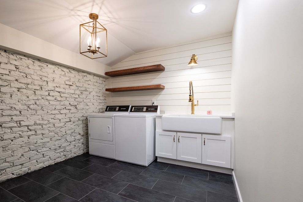 Design ideas for a large rural galley utility room in Birmingham with a belfast sink, shaker cabinets, white cabinets, engineered stone countertops, white splashback, engineered quartz splashback, white walls, slate flooring, a side by side washer and dryer, black floors, white worktops, a vaulted ceiling and tongue and groove walls.