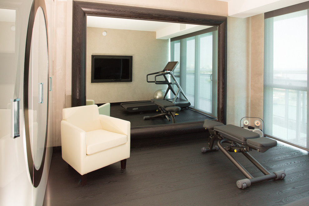 Small contemporary home weight room in Miami with beige walls and dark hardwood floors.