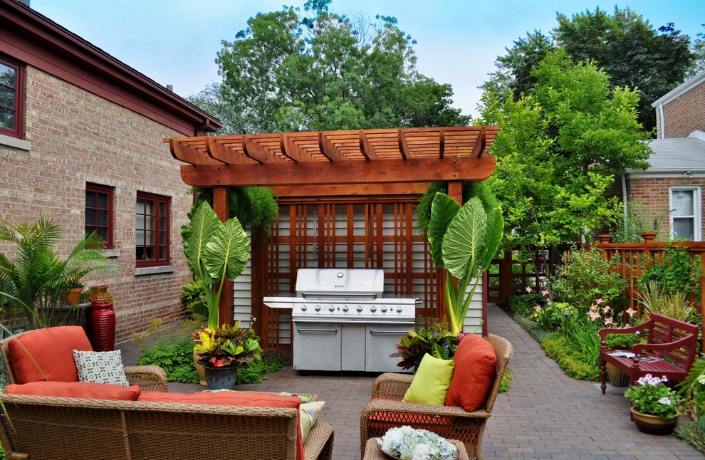 Small traditional backyard patio in Chicago with brick pavers and a pergola.
