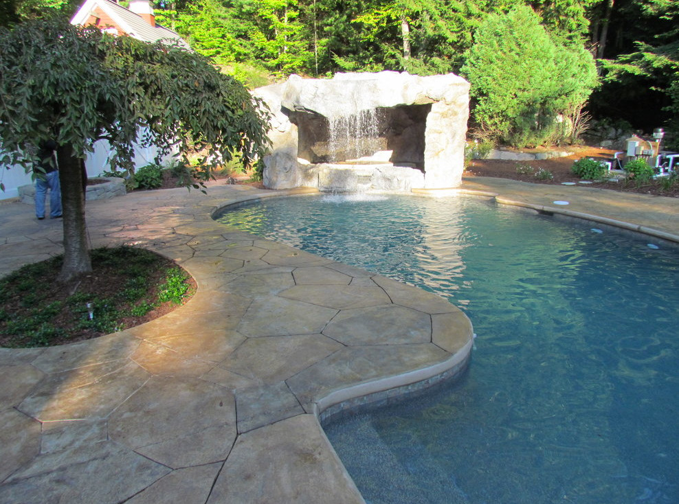 Mid-sized mountain style backyard stone and custom-shaped lap pool fountain photo in Boston
