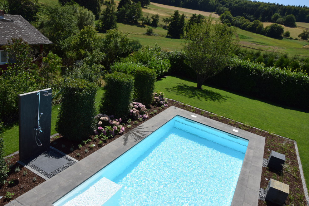 Mittelgroßer Moderner Pool neben dem Haus in rechteckiger Form mit Natursteinplatten in Frankfurt am Main