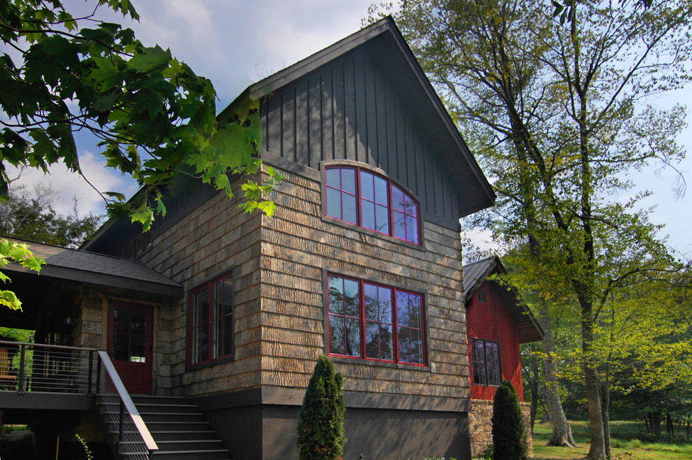 This is an example of a country two-storey exterior in Charlotte with wood siding, board and batten siding and shingle siding.