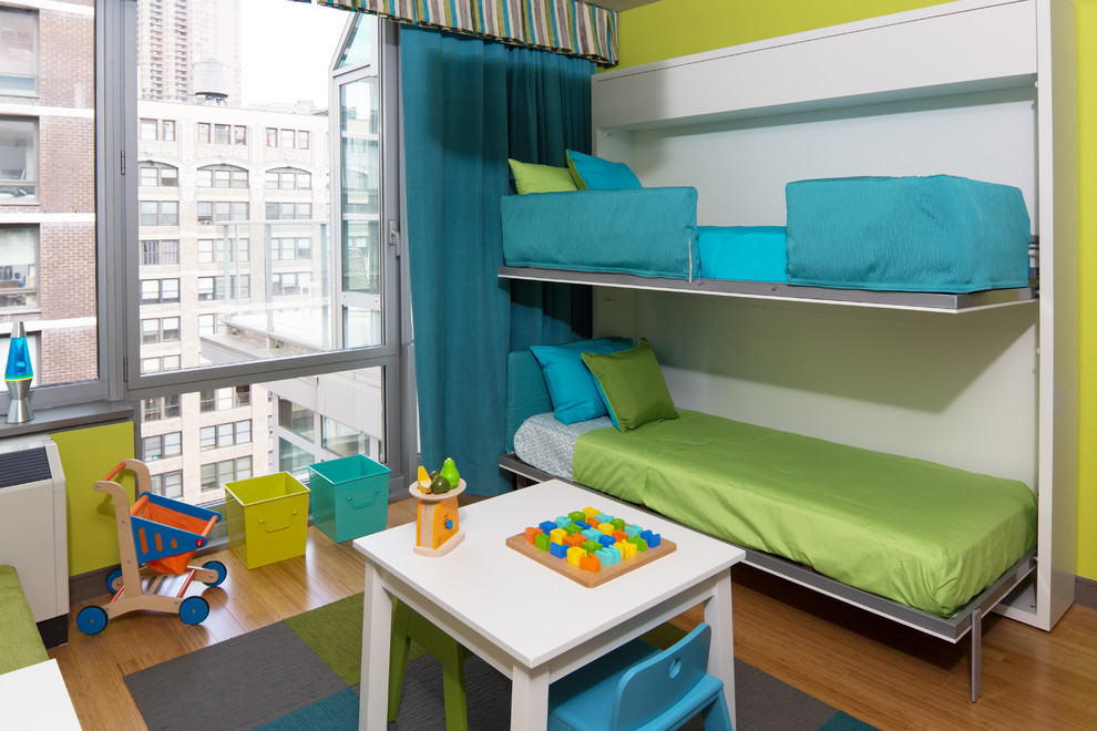 Contemporary gender-neutral kids' bedroom in New York with green walls and medium hardwood floors for kids 4-10 years old.