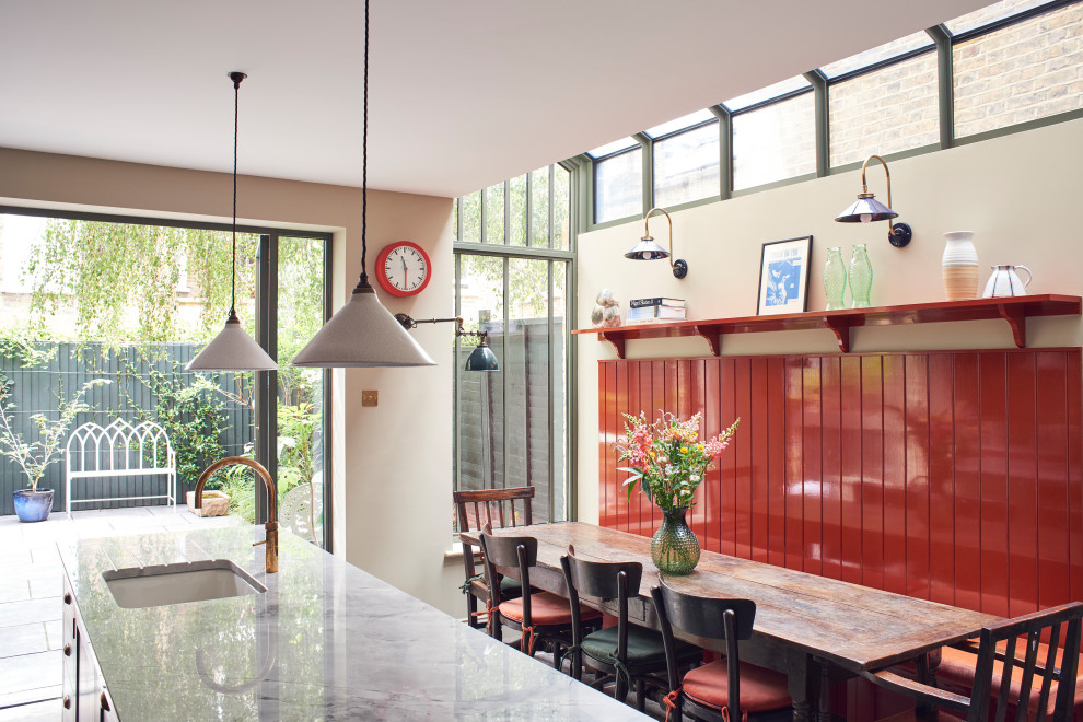 Cette image montre une salle à manger ouverte sur la cuisine victorienne avec un mur beige.