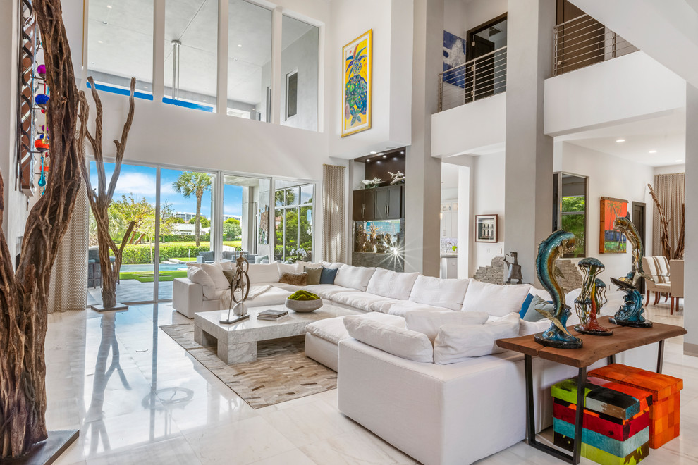 Large tropical formal open concept living room in Miami with marble floors, a standard fireplace, a metal fireplace surround, white walls and white floor.