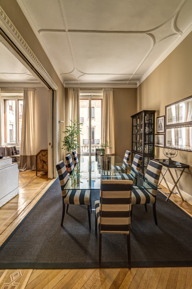 Photo of a traditional dining room in Milan with beige walls and medium hardwood floors.