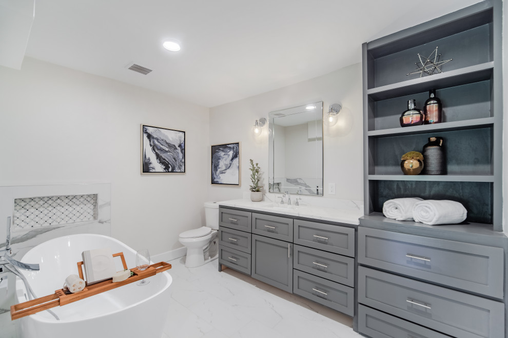 Photo of a classic bathroom in Dallas with shaker cabinets, grey cabinets, a freestanding bath, beige walls, marble flooring, a submerged sink, white worktops, a single sink and a built in vanity unit.